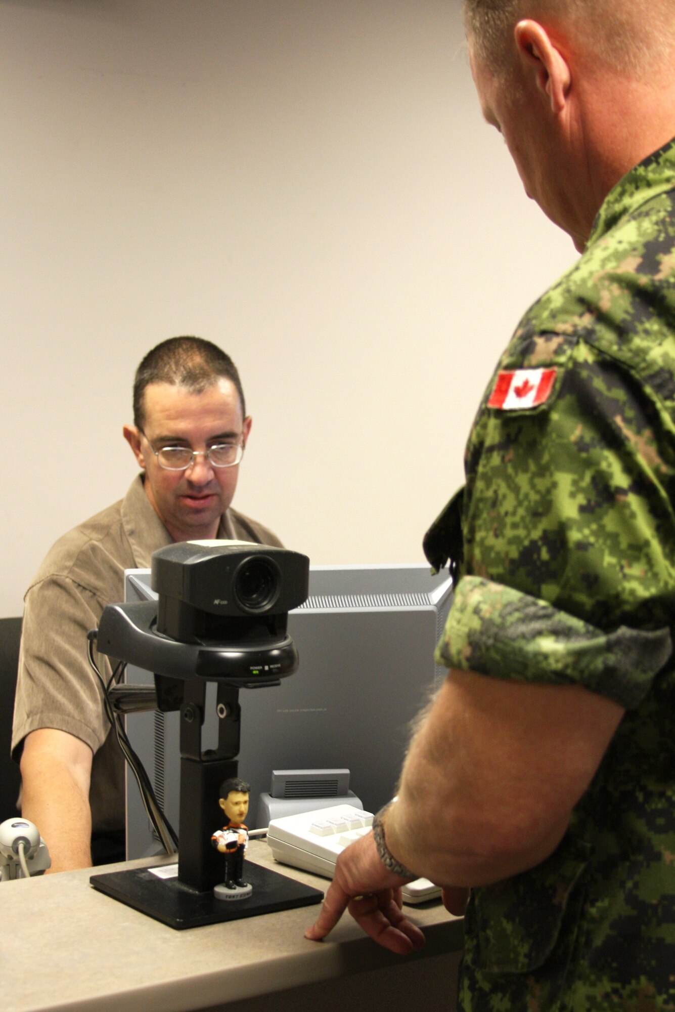 Jeff Stewart works to create a Canadian servicemember a new identification card recently. Mr.Stewart was selected for the First Knight award for the week of Aug. 7, 2008. This award is designed to recognize outstanding Airmen each week for the work they do each day. (U.S. Air Force photo/Bonnie Rivera) 