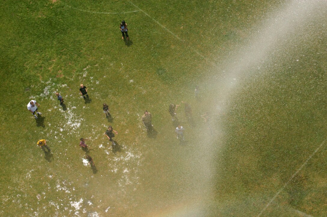 419th Fighter Wing Reservists and their families cool down beneath a manmade rainstorm produced by the Hill Air Force Base Fire Department during the wing's annual Family Day this UTA. (U.S. Air Force photo/Staff Sgt. Kyle Brasier)
