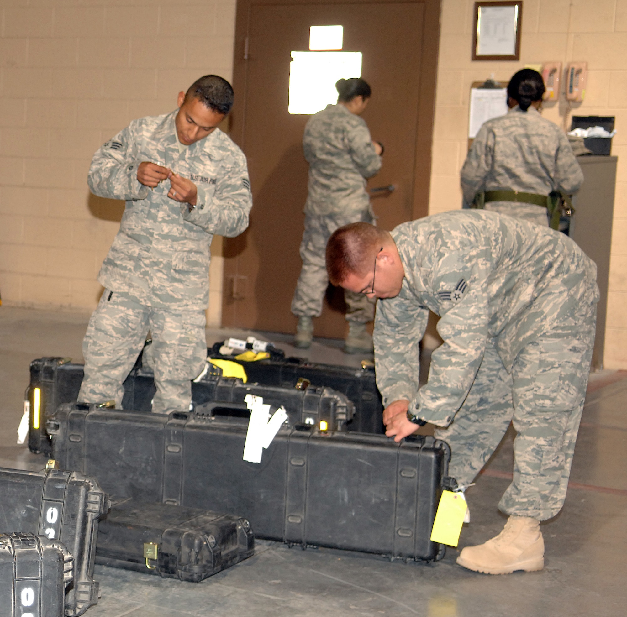Senior Airman Mario Garcia and Senior Airman Thomas OCampo, both 49th Logistics Readiness Squadron, turn in their weapons at the armory at Holloman Air Force Base, N.M., July 25. This was the first stop on base for both of the Airmen upon returning home from a deployment to Ali Air Base, Iraq. (U.S. Air Force photo/Airman Sondra M. Wieseler)