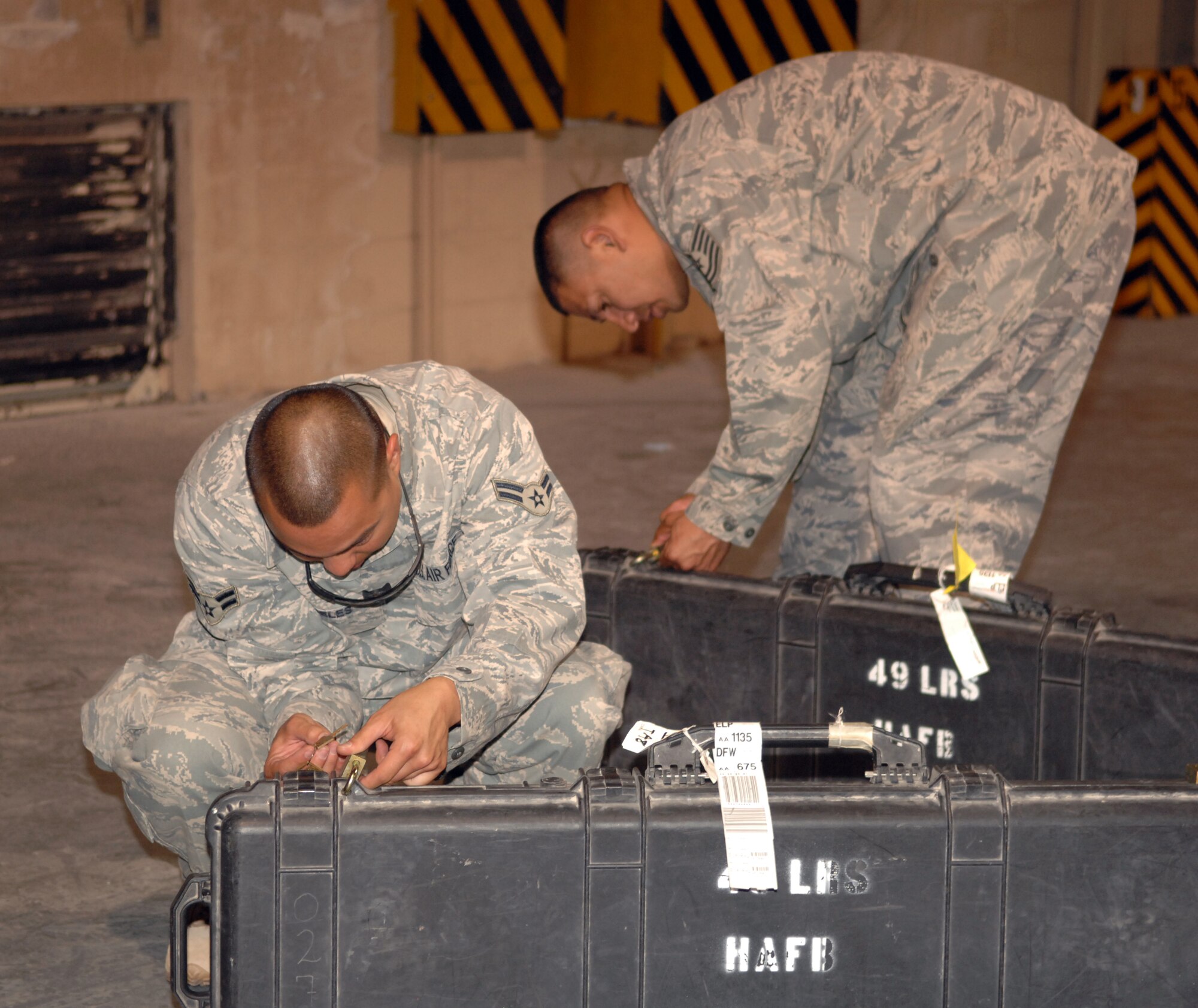 Airman 1st Class Narciso Angeles and Tech. Sgt. Alfredo Gonzales, both 49th Logistics Readiness Squadron, turn in their weapons at the armory at Holloman Air Force Base, N.M., July 25. Sergeant Gonzales is returning from a five and a half month deployment to Iraq, making it his fourth deployment.  Airman Angeles, returning from his first deployment, spent six months at Ali Air Base, Iraq. (U.S. Air Force photo/Airman Sondra M. Wieseler)