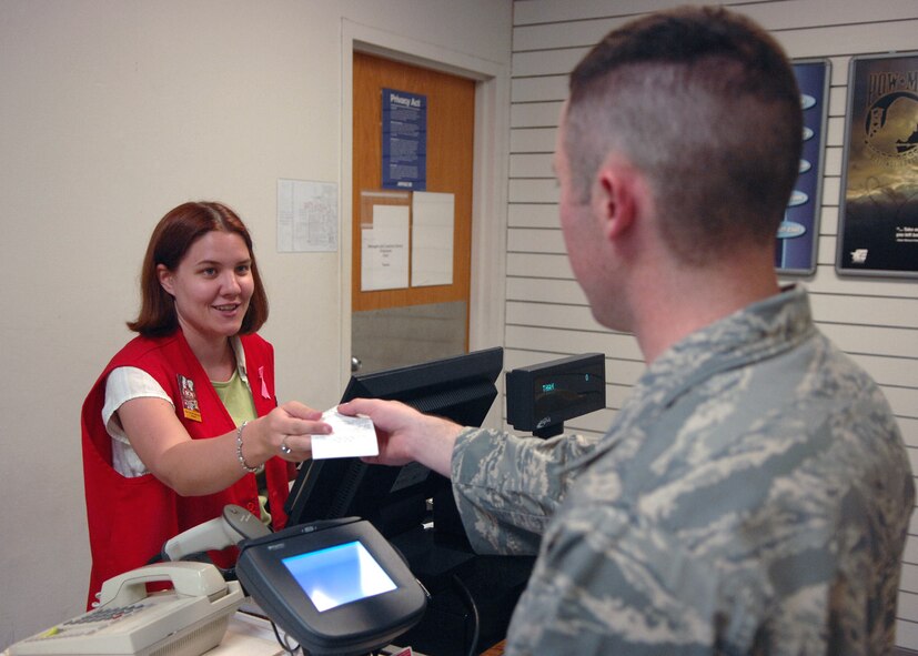MOODY AIR FORCE BASE, Ga. – Scherri Montgomery, Moody Base Exchange (BX) sales associate hands an Airman his receipt here August 1. Scherri has two years experience working at the BX customer service. (U.S. Air Force photo by Airman Joshua Green)