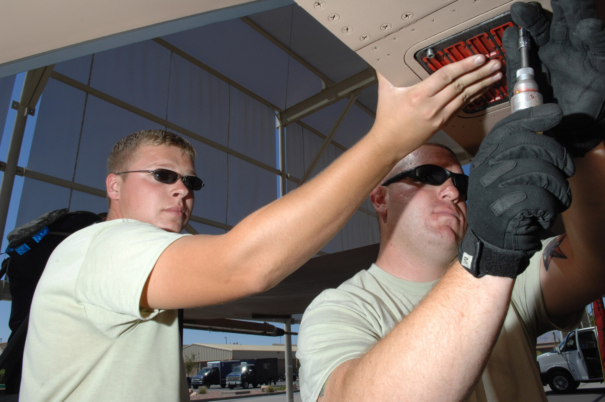 Senior Airman Gregory Strouse (left) and Staff Sgt. Sean Minnick load chaff and flares onto an F-16 Fighting Falcon July 24 at Nellis Air Force Base, Nev. The 926th Group is an Air Force Reserve unit under the 10th Air Force, Naval Air Station Joint Reserve Base, Fort Worth, Texas. The group is located at Nellis AFB as an associate unit to the Air Force Warfare Center. Through total force integration, reservists are integrated into active duty Air Force units, accomplishing the mission alongside active-duty Airmen on a daily basis. Airman Strouse is a 57th Aircraft Maintenance Squadron F-16 weapons load crew member and Sergeant Minnick is a 926th Group Det. 2 F-16 weapons loader team chief. (U.S. Air Force photo/Senior Airman Larry E. Reid Jr.)
