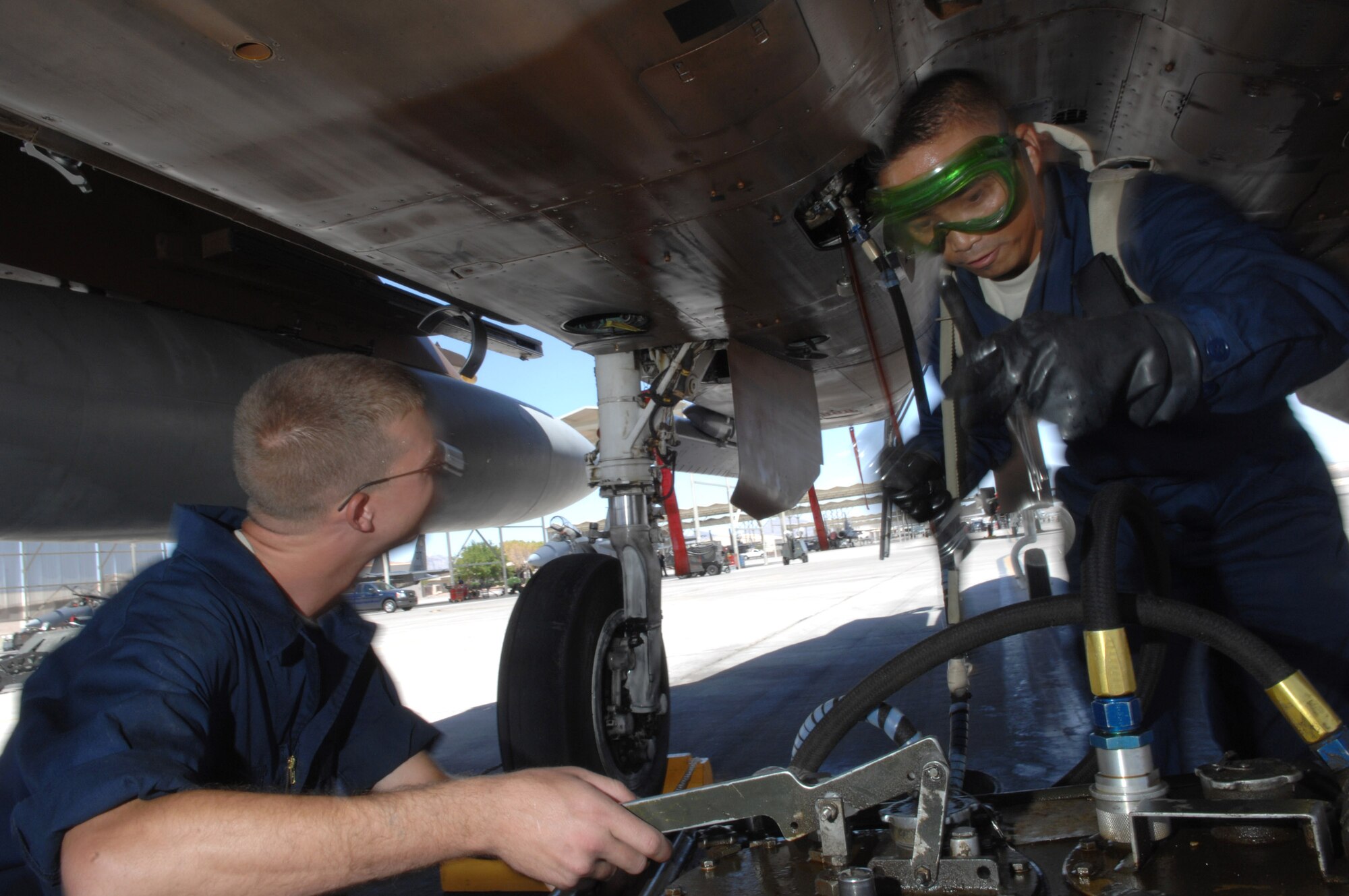 Airman 1st Class Jacob Alwell (left) and Staff Sgt. Raymond Oliveros service a generator on a F-15 Eagle July 24 at Nellis Air Force Base, Nev. The 926th Group is an Air Force Reserve unit under the 10th Air Force, Naval Air Station Joint Reserve Base, Fort Worth, Texas. The group is located at Nellis AFB as an associate unit to the Air Force Warfare Center. Through total force integration, reservists are integrated into active duty Air Force units, accomplishing the mission alongside active-duty Airmen on a daily basis. Airman Alwell is a 57th Aircraft Maintenance Squadron F-15 crew chief, and Sergeant Oliveros is an F-15 crew chief assigned to the 926th Group Det. 2. (U.S. Air Force photo/Senior Airman Larry E. Reid Jr.)
