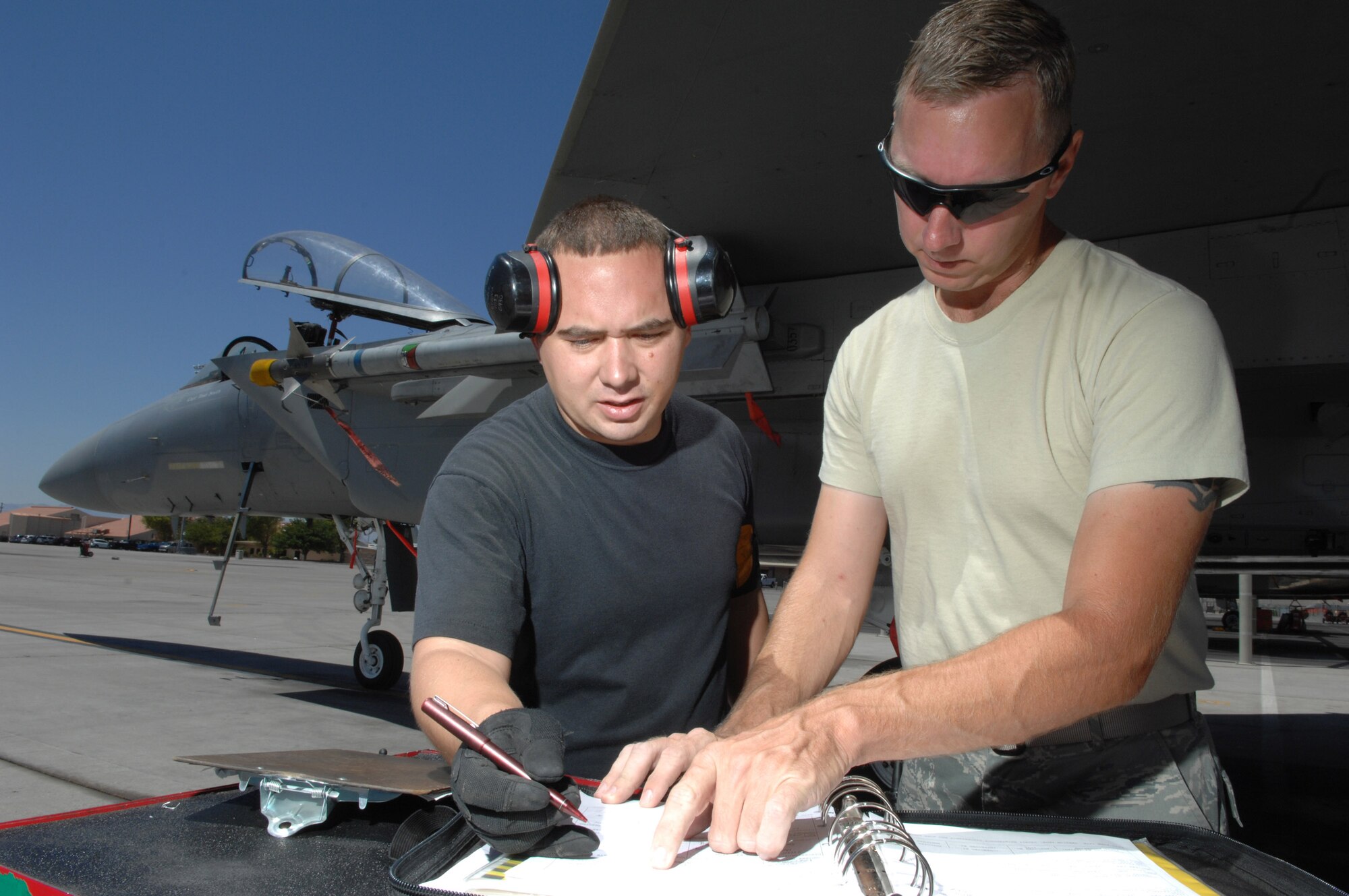 Staff Sgt. Richard Cordova (left) and Staff Sgt. Michael Adams sign off on a weapons second look inspection July 24 at Nellis Air Force Base, Nev. The 926th Group is an Air Force Reserve unit under the 10th Air Force, Naval Air Station Joint Reserve Base, Fort Worth, Texas. The group is located at Nellis AFB as an associate unit to the Air Force Warfare Center. Through total force integration, reservists are integrated into active duty Air Force units, accomplishing the mission alongside active-duty Airmen on a daily basis. Sergeant Cordova is an F-15 Eagle weapons specialist assigned to the 926th Group Det. 2, and Sergeant Adams is a 57th Aircraft Maintenance Squadron F-15 expediter. (U.S. Air Force photo/Senior Airman Larry E. Reid Jr.)
