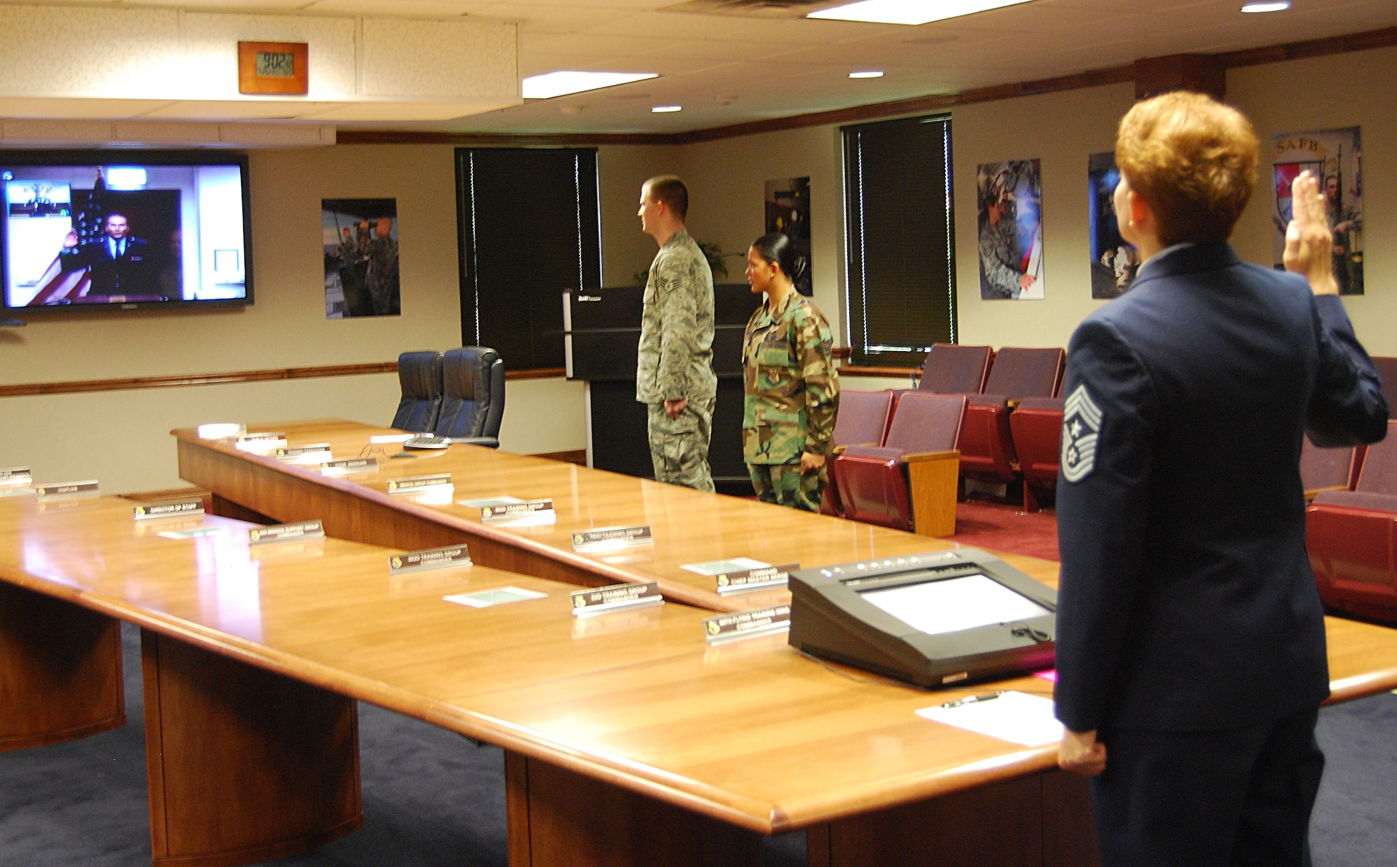 Command Chief Master Sgt. Jeannie McLean pledges to serve the U.S. during her final re-enlistment ceremony while Second Lieutenant Vincent McLean, 52nd Logistics Readiness Squadron, Spangdahlem Air Base, Germany, re-enlists his mother. The lieutenant got the honor of re-enlisting his mother via video teleconference, just weeks after she saluted him for the first time. (U.S. Air Force photo/Airman 1st Class Jacob Corbin).