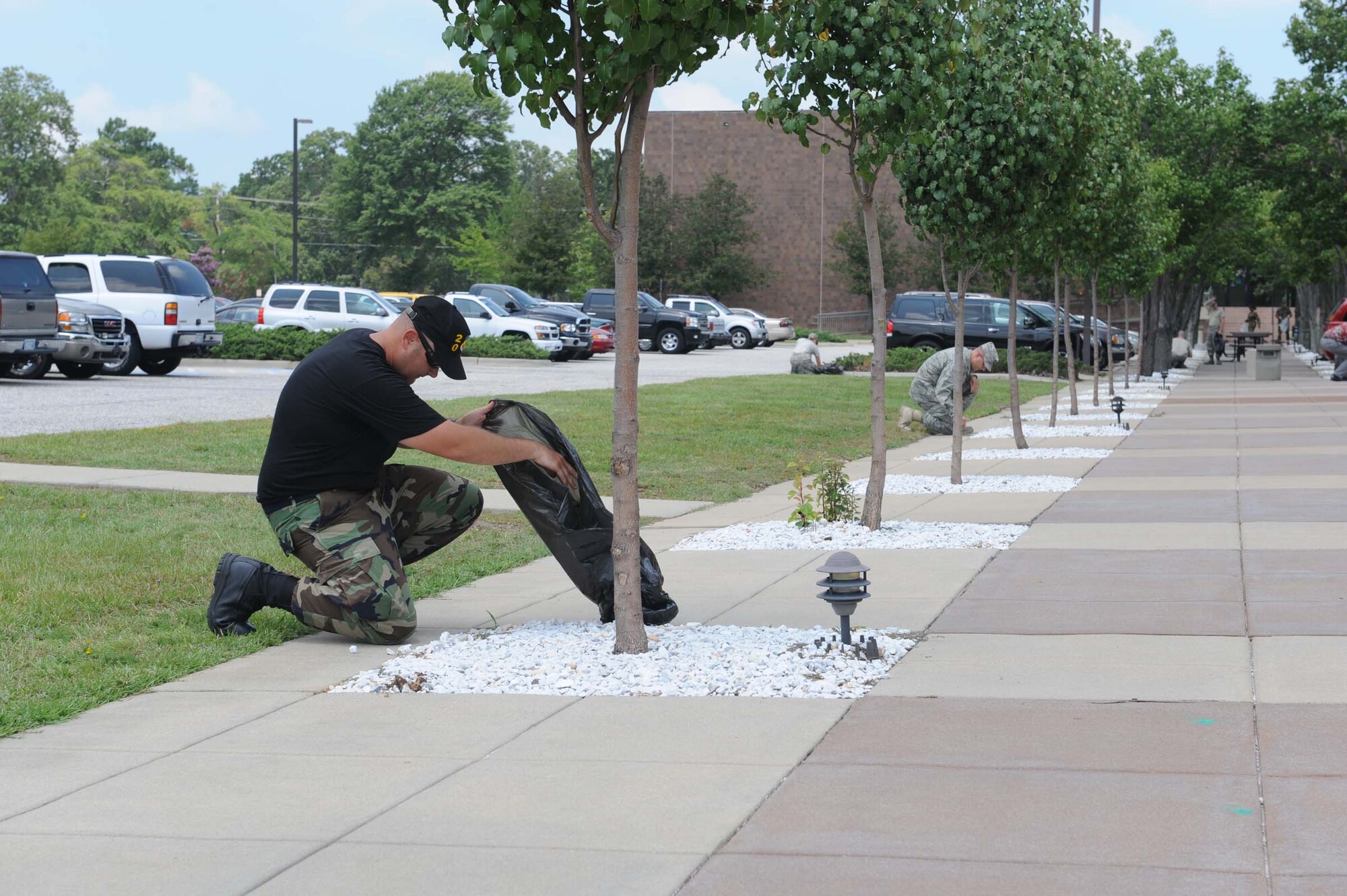 SHAW AIR FORCE BASE, S.C. -- Staff Sgt. Jason Reid, 20th Fighter Wing safety, picks up debris around the trees adjacent to Wing HQ during base clean up day Aug 1. Agencies across base were given the opportunity to clean their work space in and out prior to the LSET inspection. (U.S. Air Force photo/Staff Sgt. Henry Hoegen)