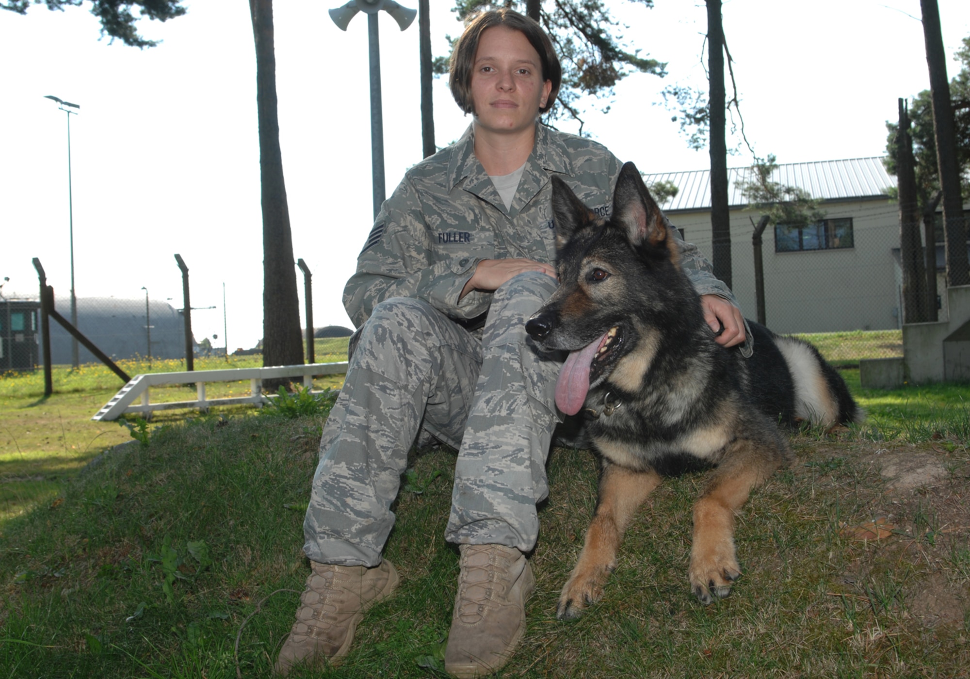 SPANGDAHLEM AIR BASE, Germany — Staff Sgt. Tricia Fuller, 52nd Security Forces Squadron, sits with her dog Agar July 31, 2008, prior to his retirement .  Agar is a German Shepherd certified in bomb detection and patrol and is getting adopted by Sergeant Fuller following his retirement.  (U.S. Air Force photo by Staff Sgt. Logan Tuttle)