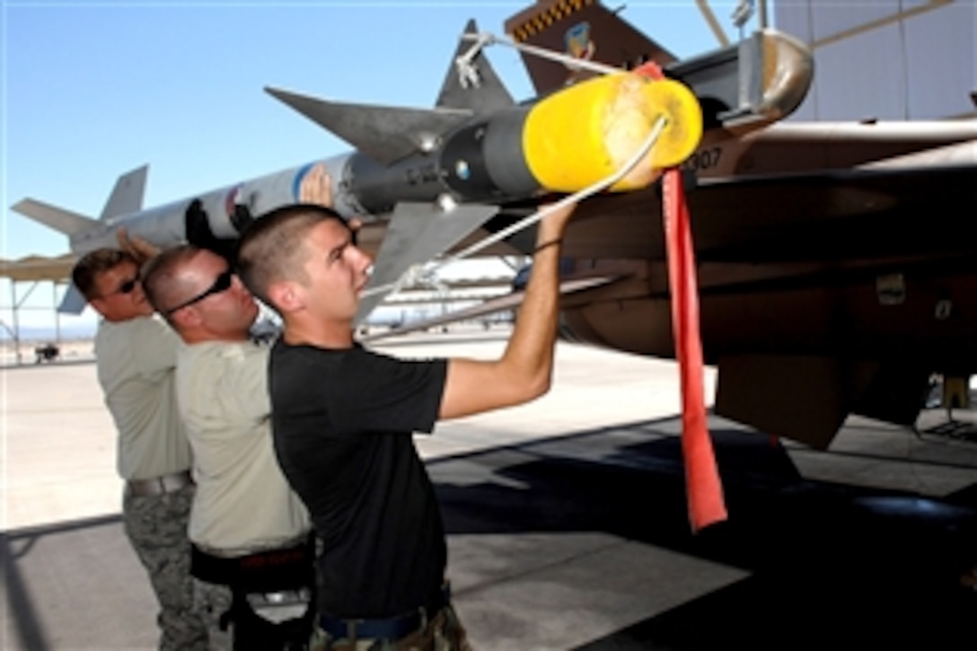 U.S. Senior Airman Gregory Strouse, left, Staff Sgt. Sean Minnick, center, and Senior Airman David Garrison, right, load a missile onto a F-16 Fighting Falcon July 24, 2008, at Nellis Air Force Base, Nev. The 926th Group is an Air Force Reserve unit under the 10th Air Force, Naval Air Station Joint Reserve Base, Fort Worth, Texas. The group is located on Nellis as an associate unit to the Air Force Warfare Center.