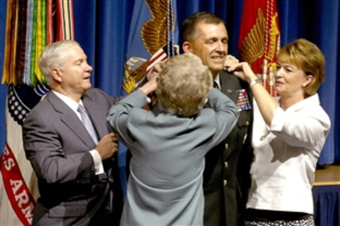Defense Secretary Robert M. Gates, left, assists Army Gen. Peter Chiarelli's mother Audrey and wife Beth, right, in pinning on four stars during Chiarelli's promotion from lieutenant general in the Pentagon, Aug. 4, 2008. During the ceremony, Chiarelli also took the oath of office as the Army's new vice chief of staff.  Chiarelli previously served as senior military assistant to Gates.  