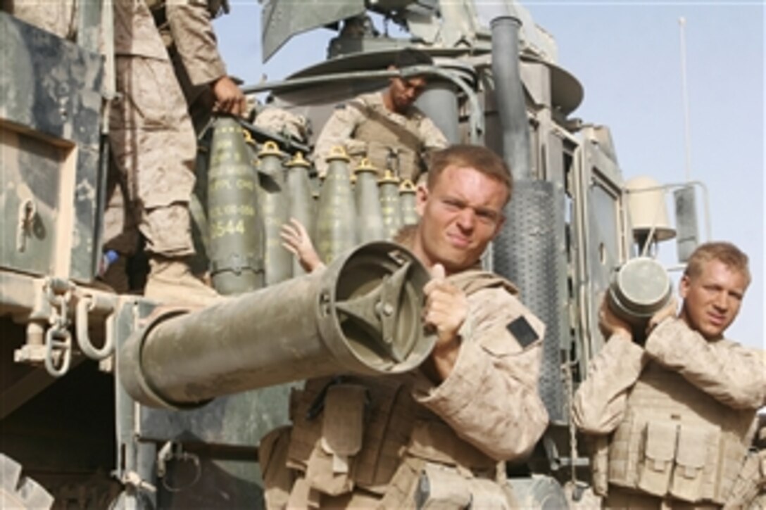 U.S. Marines with Whiskey Company, 1st Battalion, 6th Marine Regiment, 24th Marine Expeditionary Unit, NATO International Security Assistance Force unload gear from a truck in Garmsir, Afghanistan, on July 23, 2008.  