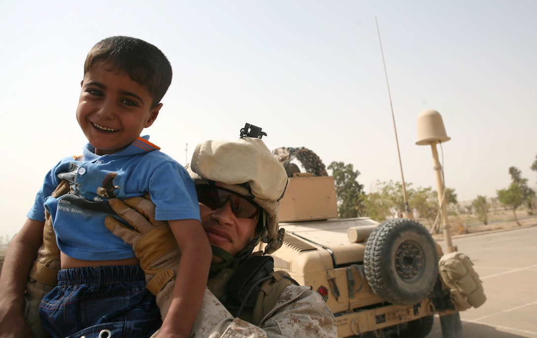 Maj. Eric P. Dominijanni, team leader, Police Transition Team 8, Regimental Combat Team 1, holds 5-year-old Ahmed and says his goodbyes before the boy is transported to medical facilities in Jordan. The team worked for several months to help Ahmed get the medical attention he needed to treat a hole in his heart.