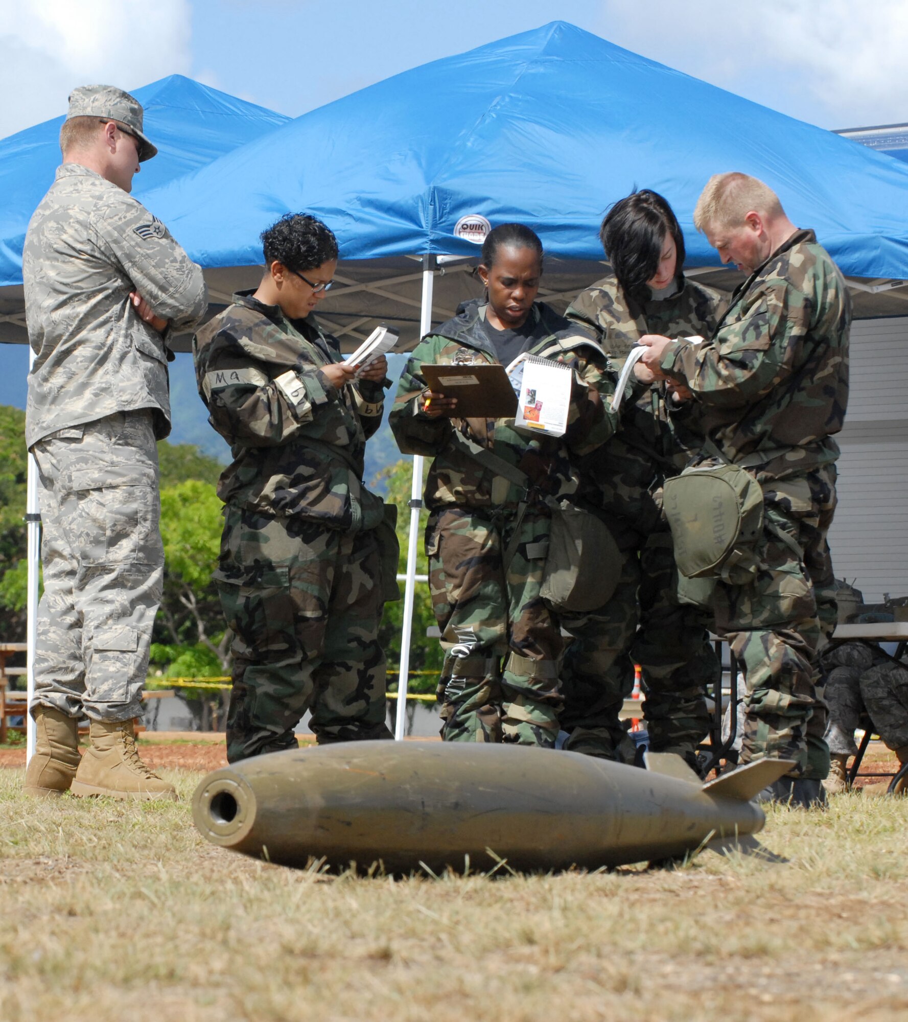 Senior Airman Chelby Allen, 15th Services Squadron; Staff Sgt. Desiree Penn, 15th Civil Engineer Squadron; Airman Erin Hammon, 15th Operations Support Squadron and Master Sgt. Dennis Wood refer to their Airman’s Manual for guidance when classifying unexploded ordnances. (U.S. Air Force photo/Staff Sgt. Erin Smith)