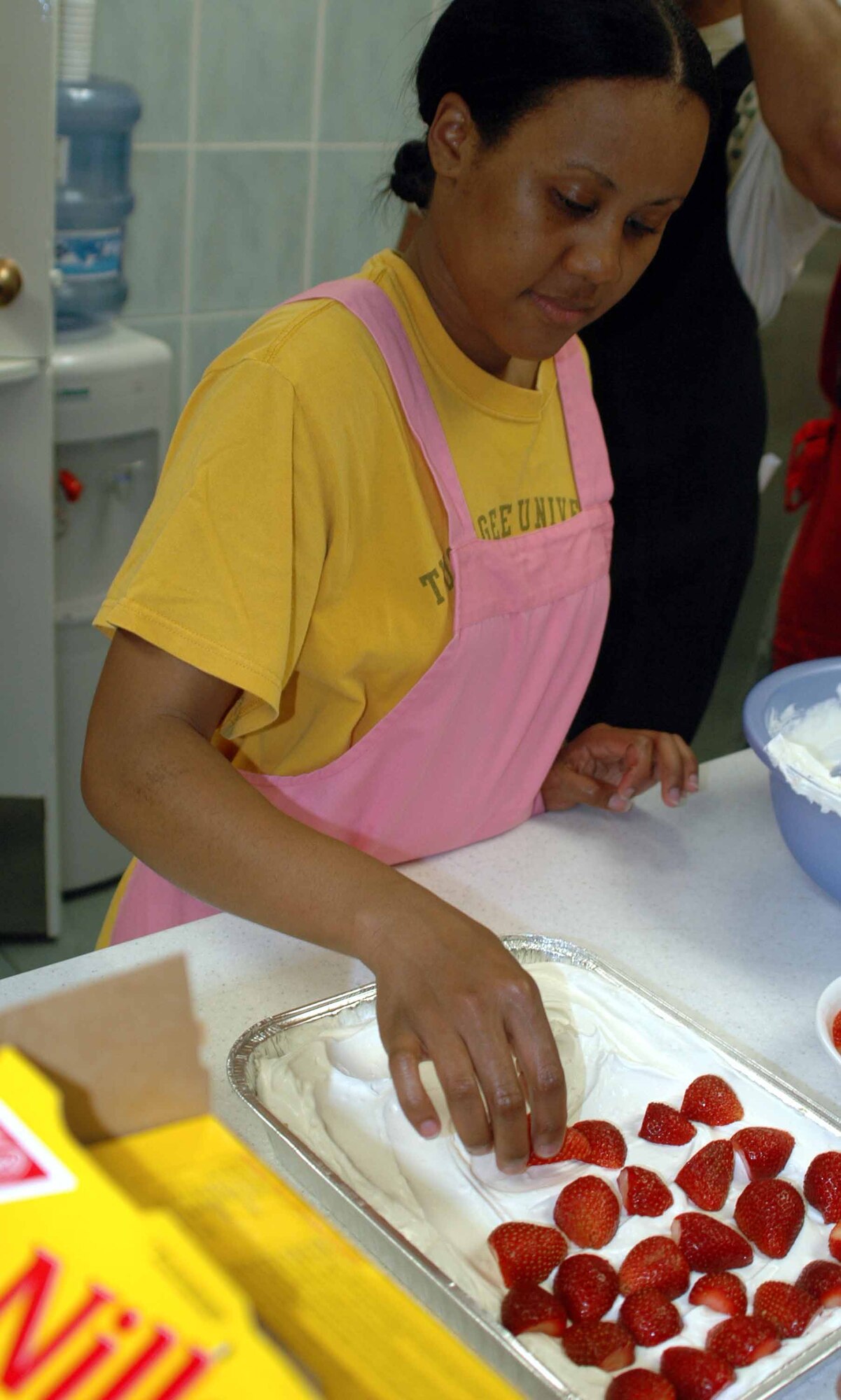 OSAN AIR BASE, Republic of Korea -- Astria Collins adds the finishing touches, fresh strawberries, to the Yum Yum Strawberry Delight dessert during the Just Desserts cooking class held Aug. 5 at the Airman and Family Readiness Center. Strawberries are the main ingredient in the Yum Yum Strawberry Delight dessert. The AFRC hosts several different cooking classes including Southern, Cajun and Caribbean styles. (U.S. Air Force photo/Staff Sgt. Candy Knight)