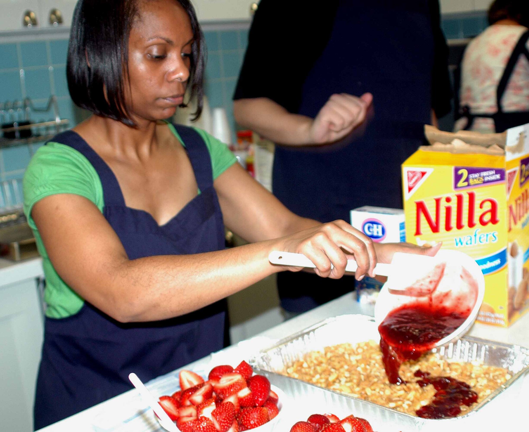 OSAN AIR BASE, Republic of Korea -- Kathleen Ivey, Just Desserts cooking class instructor pours strawberry filling onto the Yum Yum Strawberry Delight dessert cookie crust during the Just Desserts cooking class held Aug. 5 at the Airman and Family Readiness Center. The dessert cooking class is one of several different cooking classes hosted by the AFRC. (U.S. Air Force photo/Staff Sgt. Candy Knight)