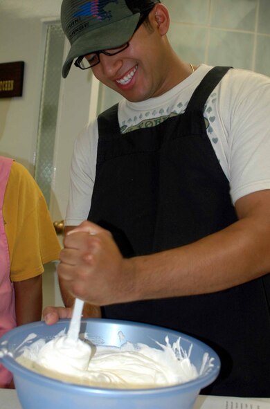OSAN AIR BASE, Republic of Korea -- Ronald Intriago mixes Cool Whip and cream cheese together during the Just Desserts cooking class held Aug. 5 at the Airman and Family Readiness Center. The Cool Whip and cream cheese was used as frosting for the Yum Yum Strawberry Delight dessert. (U.S. Air Force photo/Staff Sgt. Candy Knight)