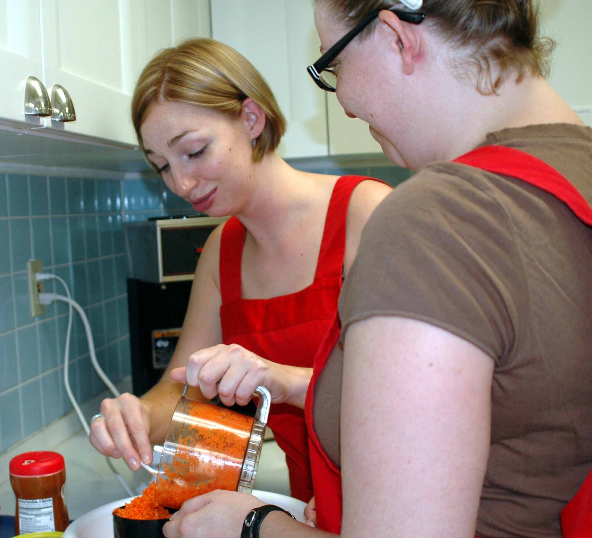 OSAN AIR BASE, Republic of Korea -- Ashley Wasinger, (left), and Alexis Brawn measures the right amount of shredded carrots needed for their Carrot Cake with Pineapple dessert during the Just Desserts cooking class held Aug. 5 at the Airman and Family Readiness Center. The dessert cooking class is just one of several cooking class hosted by the AFRC. (U.S. Air Force photo/Staff Sgt. Candy Knight)