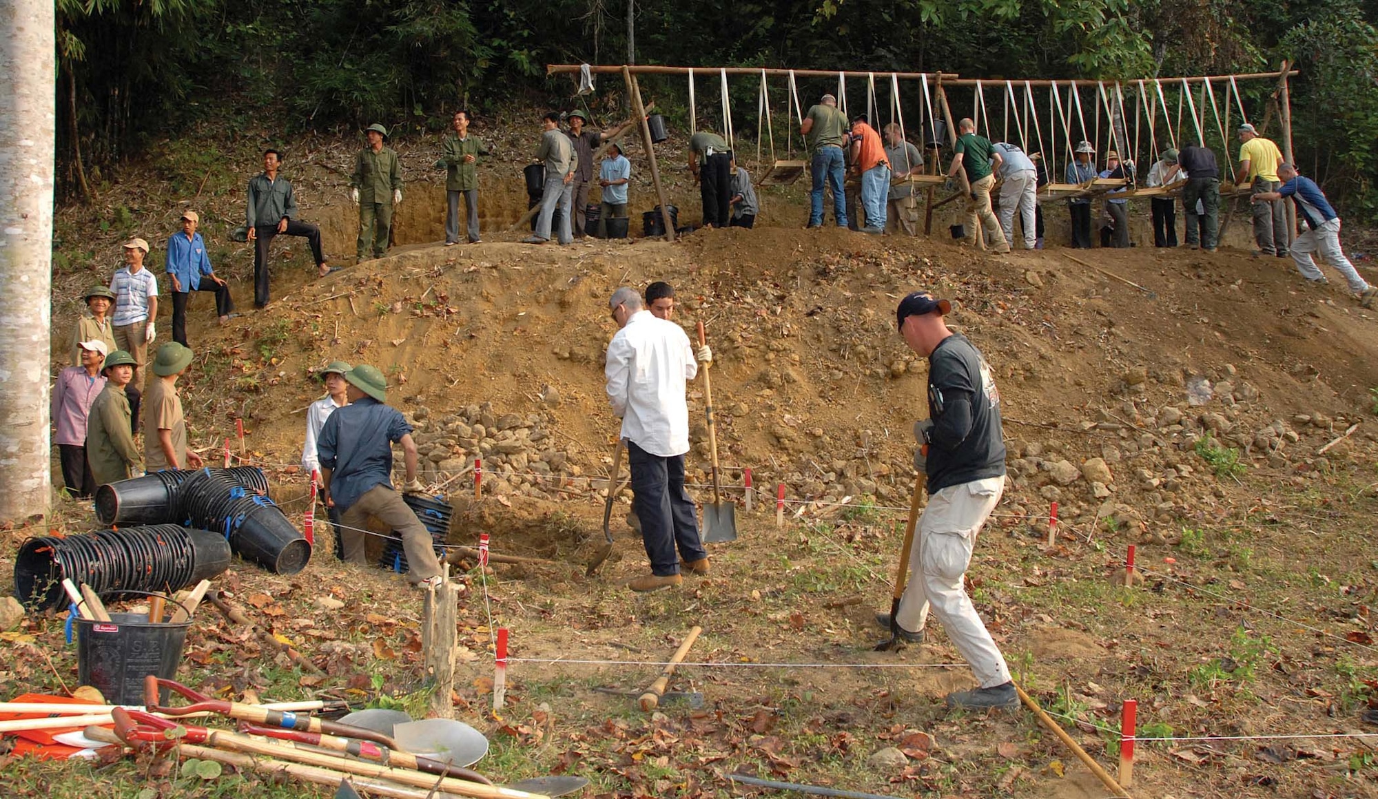 Recovery team members from the Joint POW/MIA Accounting Command dig into a unit of an excavation site in Tuyen Qaung province, Vietnam on Nov. 23, 2007.  Air Force Reservist Master Sgt. Chris Rumley, 446th Civil Engineer Squadron, McChord Air Force Base Wash.,  was part of a similar team Jan. 4 through March 3 this year. Sergeant Rumley provided explosive ordnance disposal expertise in  support of JPAC's worldwide mission to search for, recover, and identify missing Americans lost as a result of service to their nation. (U.S. Army photo/Sgt. Kaily Brown)   