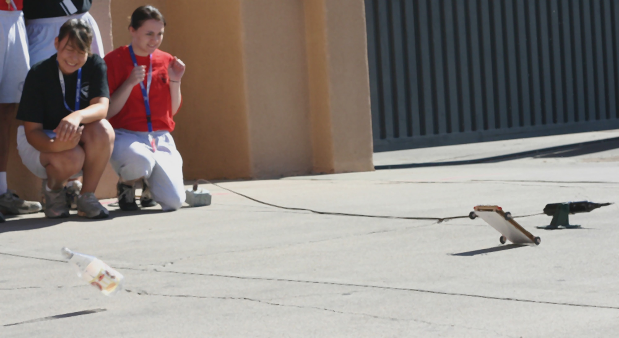 Air Force Junior ROTC Cadets Alexa Solorio from Arizona and Amber Muston from Utah wince as their rocket car bottle explodes off the frame July 29 during preliminary tests for the rocket car contest at Albuquerque, N.M. The cadets were participating in 2008 Air Force Junior ROTC Aerospace and Technology Honor Camp (U. S. Air Force photo/Staff Sgt. Jason Lake)