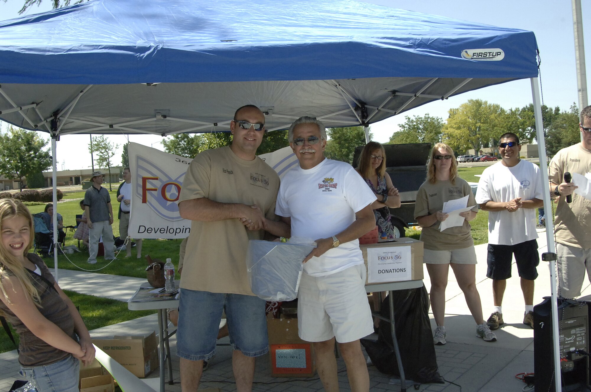 MOUNTAIN HOME AIR FORCE BASE, Idaho -- Hank Menges, accepts a prize from Tech. Sgt. Paul Tancredi, Focus 56 vice president, after taking first place in the Corvette category at the Focus 56 Auto Showdown Aug. 2 at Holt Park. Mr. Menges won with a 1995 blue coupe Corvette. The Valley Corvettes brought 18 corvettes from a 1954 to a 2008 to support the Auto Showdown, which raised more than $900 for the Focus 56 Council. (U.S. Air Force photo by Staff Sgt. Jasmine Reif) 
