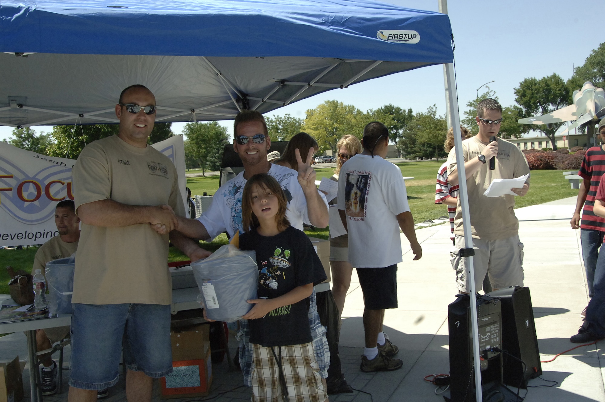 MOUNTAIN HOME AIR FORCE BASE, Idaho -- John Pennell and his son, Dante, accept their prize from Tech. Sgt. Paul Tancredi, Focus 56 vice president, after taking first place in the car category at the Focus 56 Auto Showdown Aug. 2 at Holt Park. Mr. Pennell's blue Nissan Fairlady Z, was the crowd favorite as kids of all ages crowded around and in the vehicle throughout the day.(U.S. Air Force photo by Staff Sgt. Jasmine Reif) 