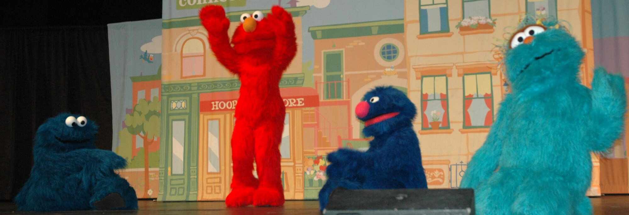 Elmo, a character from Sesame Street, tells a story to the other muppets gathered around him. Sesame Street put on a live performance at Northridge High School for the military and families August 1.  (U.S. photo by Airman 1st Class Robby Hedrick)