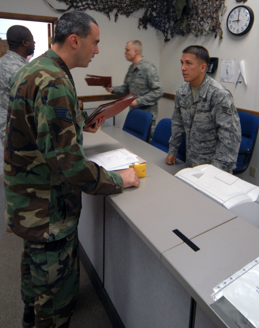Staff Sgt. Jose Santiago (right), 12th Mission Support Squadron, discusses deployment processes to Staff Sgt. Ryan Kennedy, 12th Security Forces Squadron, during the last deployment line at the former deployment readiness center in Hangar 52 July 23. The DRC moved to Hangar 71 in an effort to streamline information distribution and equipment storage for servicemembers and civilians training for and deploying to support the Global War on Terror. (U.S. Air Force photo by Steve White)