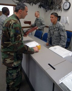 Staff Sgt. Jose Santiago (right), 12th Mission Support Squadron, discusses deployment processes to Staff Sgt. Ryan Kennedy, 12th Security Forces Squadron, during the last deployment line at the former deployment readiness center in Hangar 52 July 23. The DRC moved to Hangar 71 in an effort to streamline information distribution and equipment storage for servicemembers and civilians training for and deploying to support the Global War on Terror. (U.S. Air Force photo by Steve White)
