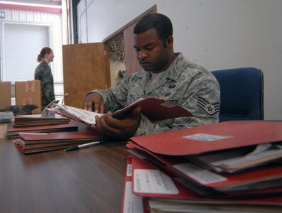 Staff Sgt. Gregory Hall, 12th Mission Support Squadron, goes over paperwork during the last deployment line at the former deployment readiness center in Hangar 52 July 23. The DRC moved to Hangar 71 in an effort to streamline information distribution and equipment storage for servicemembers and civilians training for and deploying to support the Global War on Terror. (U.S. Air Force photo by Steve White)