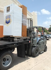 Eddie Lozano, 12th Logistics Readiness Division individual protective equipment element materials handler, uses a forklift to move items from Hangar 52 into Hangar 71. The deployment readiness center moved to Hangar 71 in an effort to streamline information distribution and equipment storage for servicemembers and civilians training for and deploying to support the Global War on Terror. (U.S. Air Force photo by Rich McFadden)