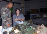 Staff Sgt. Cory Chandler, 12th Contracting Squadron, and Kezia Hillary, 12th Logistics Readiness Division individual protective equipment element materials handler, go over his deployment gear in the new deployment readiness center July 25. The DRC moved to Hangar 71 in an effort to streamline information distribution and equipment storage for servicemembers and civilians training for and deploying to support the Global War on Terror. Sergeant Chandler is the first person to deploy from the DRC's new location. (U.S. Air Force photo by Rich McFadden)