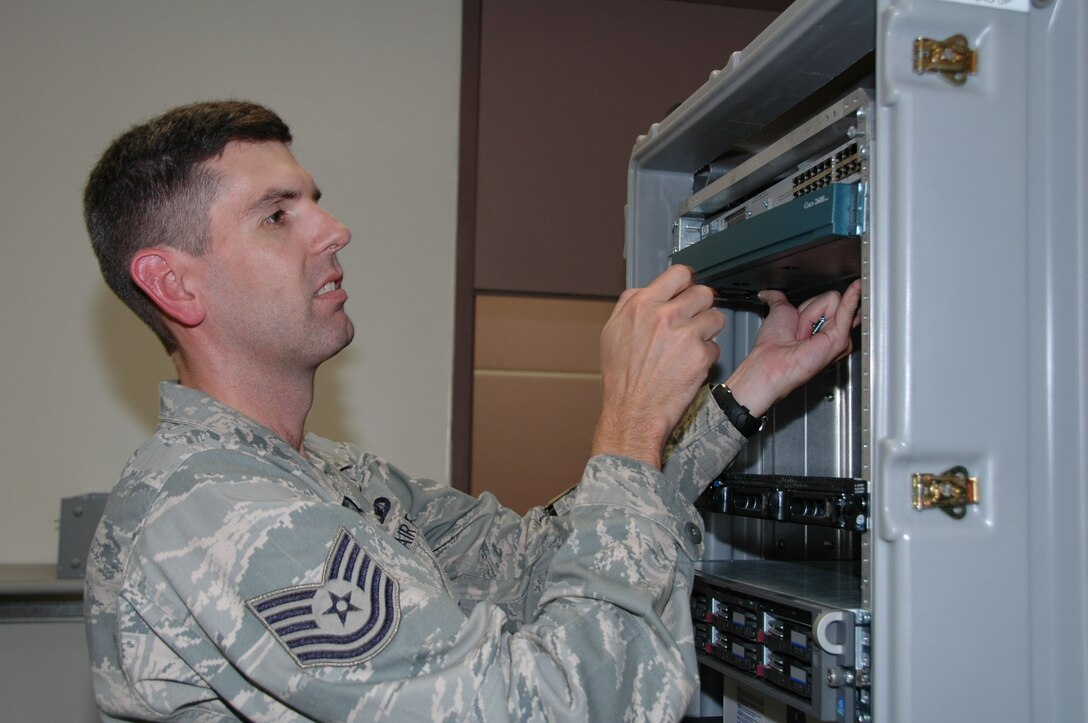 KEESLER AIR FORCE BASE, Miss.-- Tech. Sgt. Robert Martin, 403rd Communications Flight network administrator, installs a router in the flight's new Network Training Work Center during the August Unit Training Assembly. The center is designed to simulate two linked networks set up at separate geographic locations. Having the work center up and running provides the Citizen Airman of the 403rd CF with a valuable training tool for sharpening their network skills. (U.S. Air Force Photo/Tech. Sgt. Ryan Labadens)