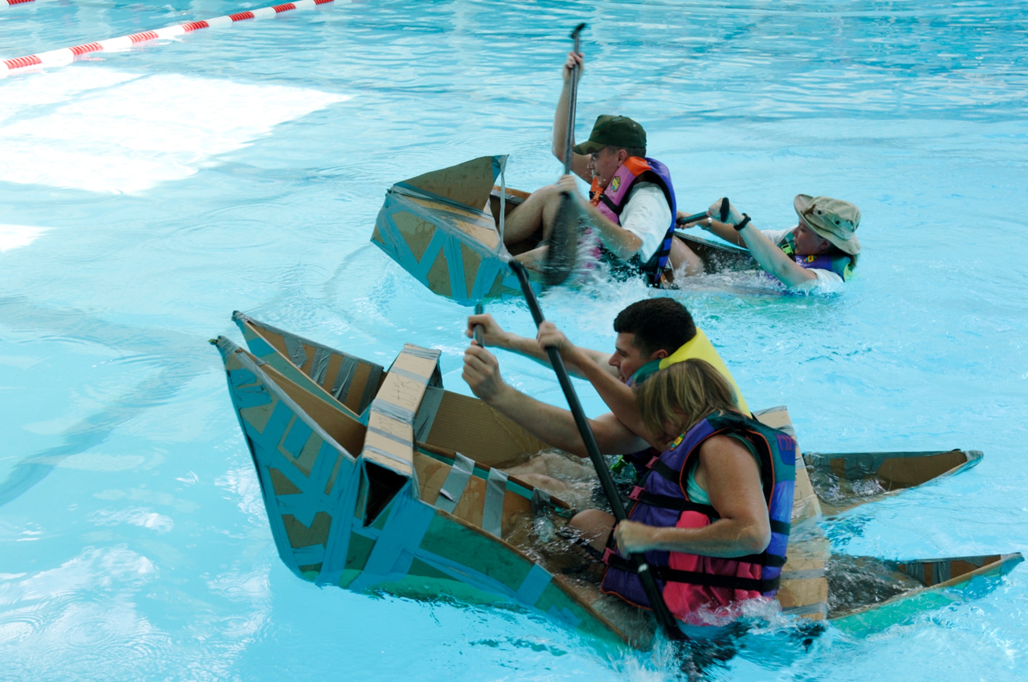 HANSCOM AFB, Mass. – Teams from the 350th Electronic Systems Wing and Electronic Systems Center Staff compete to a photo finish during the Build a Boat race at the base pool on Aug. 1, as part of the Commander’s Cup Challenge. The 551st Electronic Systems Wing received first place honors in the competition that included a number of sporting events.  (U.S. Air Force photo by Rick Berry)