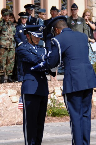 Members of the Nellis Air Force Base Honor Guard put three shells from the 21-gun salute into the fold of the cased American Flag during Lt. Col. Thomas Bouley's Memorial Service at the Base Chapel on Nellis Air Force Base, Nev., Aug. 4, 2008.
(U.S. Air Force photo / Senior Airman Jason R. Huddleston, RELEASED)