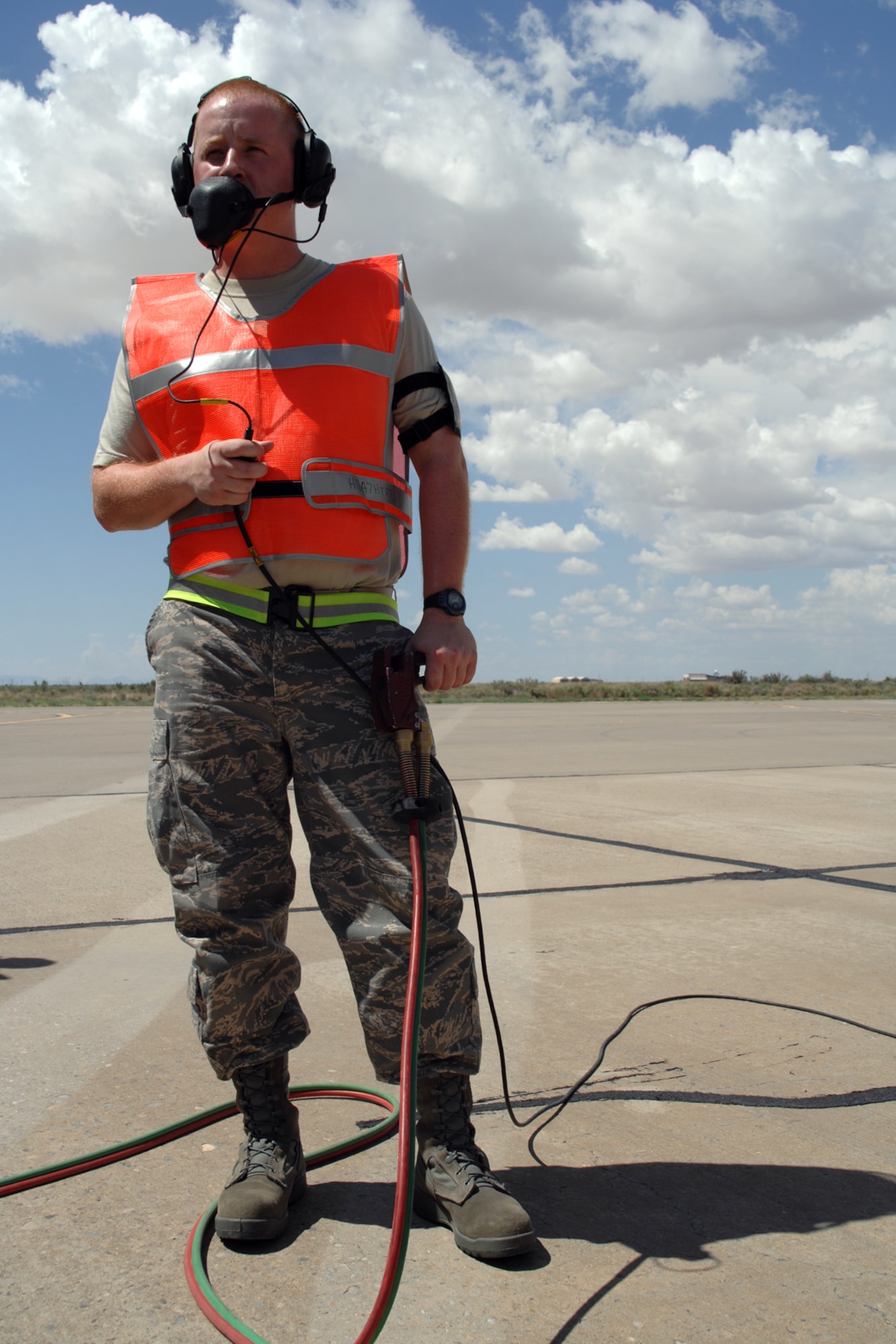 Tech. Sgt. Dennis Thomas, 49th Aircraft Maintenance Squadron, operates a 'dead man' during the hot refueling of an F-22A Raptor July 23 at Holloman Air Force Base, N.M. Different from a normal refueling, the crew chief operates the dead man because he has direct communication with the pilot and can stop the refueling at a moments notice if need be. (U.S. Air Force photo/Airman 1st Class Jamal D. Sutter)