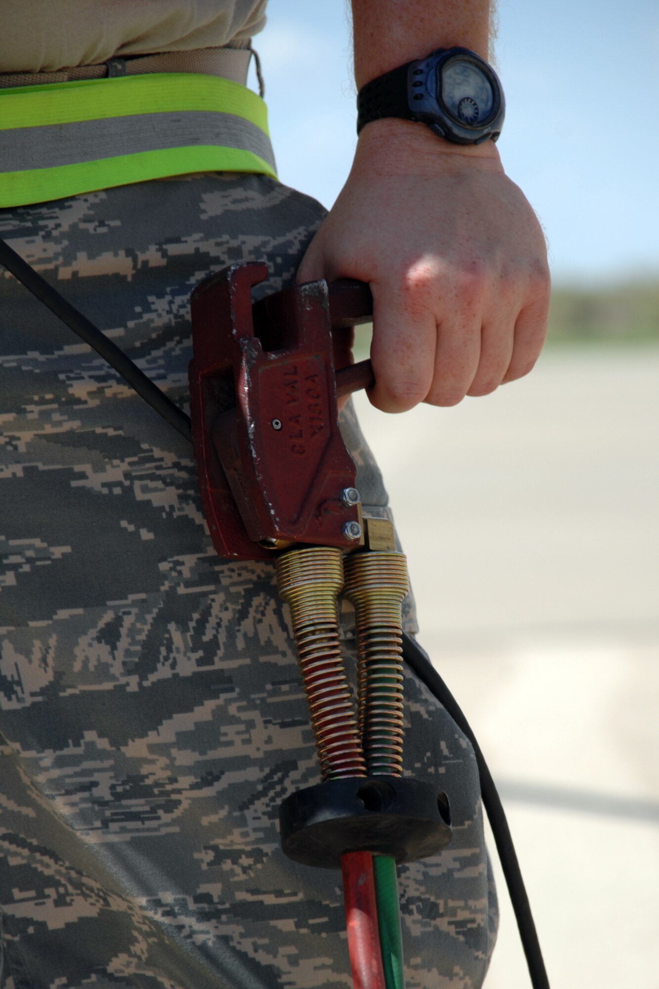 Tech. Sgt. Dennis Thomas, 49th Aircraft Maintenance Squadron, operates a 'dead man' during the hot refueling of an F-22A Raptor July 23 at Holloman Air Force Base, N.M. A dead man is the tool used to start and stop fuel from leaving the fuel truck and entering the aircraft. (U.S. Air Force photo/Airman 1st Class Jamal D. Sutter)
