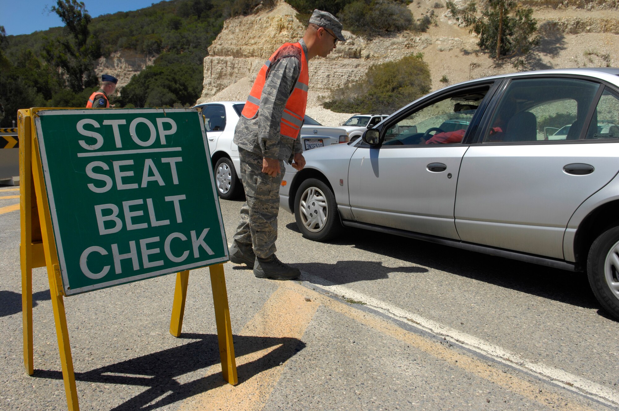 VANDENBERG AIR FORCE BASE, Calif-- Maj. Jerame Cohen of the 30th Logistics Readiness Squadron makes seat belt checks at the Lompoc Gate here Aug. 1. (U.S. Air Force photo/Airman 1st Class Andrew Lee)