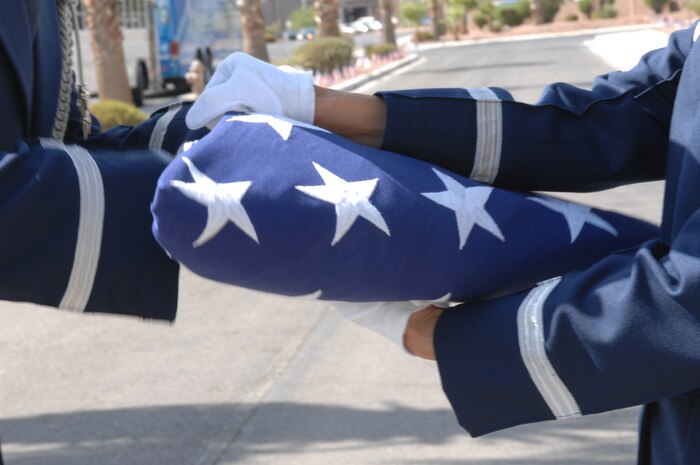 Members of the Nellis Air Force Base Honor Guard put three shells from the 21-gun salute into the American Flag to present to Lt. Col. Thomas Bouley's family during his Memorial Service at the Nellis Base Chapel on Nellis Air Force Base, Nev., Aug. 4, 2008.
(U.S. Air Force photo / Airman First Class Brett C. Clashman, RELEASED)