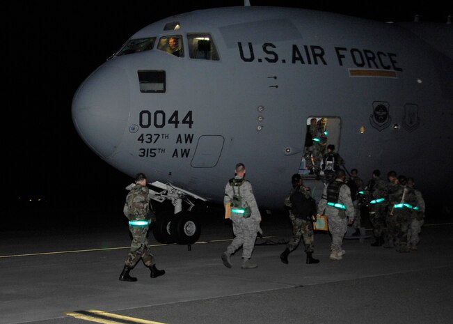 Team Charleston members board a Charleston AFB C-17 on the flightline during the Headquarters Air Mobility Command Operational Readiness Inspection Aug. 4.  Headquarters inspectors are evaluating the 437th and 315th Airlift Wings' capability to generate aircraft, deploy Airmen and cargo and employ from a forward location in support of global military operations.(U.S. Air Force photo/Airman 1st Class Katie Gieratz)