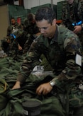 Senior Airman Frank Martinez inspects his mobility bag at the personnel deployment facility during the Headquarters Air Mobility Command Operational Readiness Inspection Aug. 4.  Headquarters inspectors are evaluating the 437th and 315th Airlift Wings' capability to generate aircraft, deploy Airmen and cargo and employ from a forward location in support of global military operations. Airman Martinez is a firefighter from the 315th Civil Engineer Squadron.  (U.S. Air Force photo/Airman 1st Class Katie Gieratz)