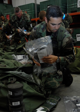 Senior Airman Frank Martinez inspects his mobility bag at the personnel deployment facility during the Headquarters Air Mobility Command Operational Readiness Inspection Aug. 4.  Headquarters inspectors are evaluating the 437th and 315th Airlift Wings' capability to generate aircraft, deploy Airmen and cargo and employ from a forward location in support of global military operations. Airman Martinez is a firefighter from the 315th Civil Engineer Squadron.  (U.S. Air Force photo/Airman 1st Class Katie Gieratz)