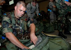 Staff Sgt. Travis Gregg inspects his mobility bag at the personnel deployment facility during the Headquarters Air Mobility Command Operational Readiness Inspection Aug. 4.  Headquarters inspectors are evaluating the 437th and 315th Airlift Wings' capability to generate aircraft, deploy Airmen and cargo and employ from a forward location in support of global military operations. Sergeant Gregg is a firefighter from the 315th Civil Engineer Squadron.  (U.S. Air Force photo/Airman 1st Class Katie Gieratz)