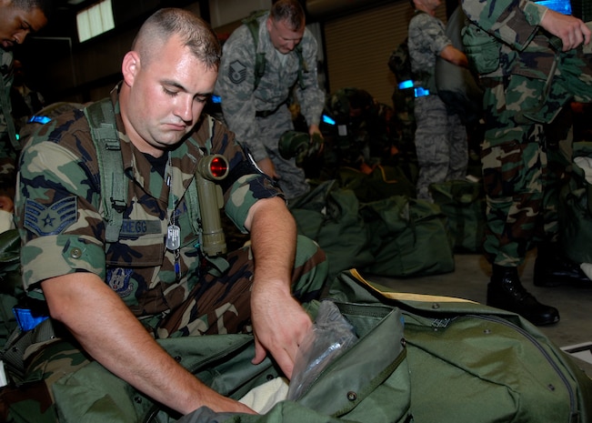 Staff Sgt. Travis Gregg inspects his mobility bag at the personnel deployment facility during the Headquarters Air Mobility Command Operational Readiness Inspection Aug. 4.  Headquarters inspectors are evaluating the 437th and 315th Airlift Wings' capability to generate aircraft, deploy Airmen and cargo and employ from a forward location in support of global military operations. Sergeant Gregg is a firefighter from the 315th Civil Engineer Squadron.  (U.S. Air Force photo/Airman 1st Class Katie Gieratz)