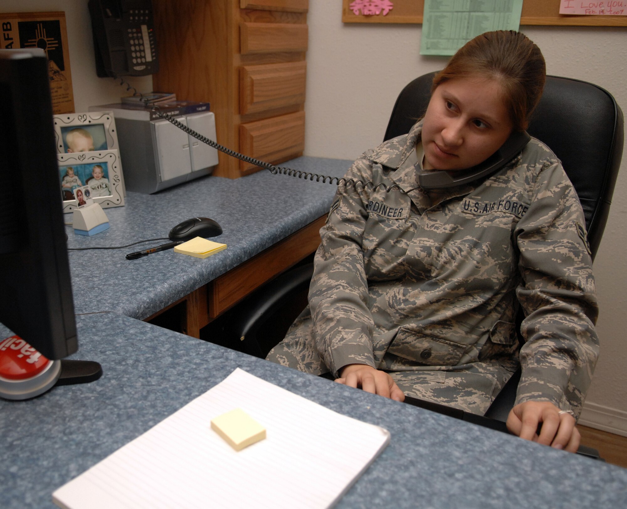 Airman 1st Class Lindy Gordineer, 49th Maintenace Squadron, answers a customer service phone call while remoting into a computer to update it at Holloman Air Force Base, N.M., July 31. Airman Gordineer is a member of the 49th Maintenance Group Small Computers Shop and along with performing customer service for the group, they also set up, repair and maintain government computers as well as ensure they are compliant with Air Combat Command requirements. (U.S. Air Force photo/Airman Sondra M. Wieseler)