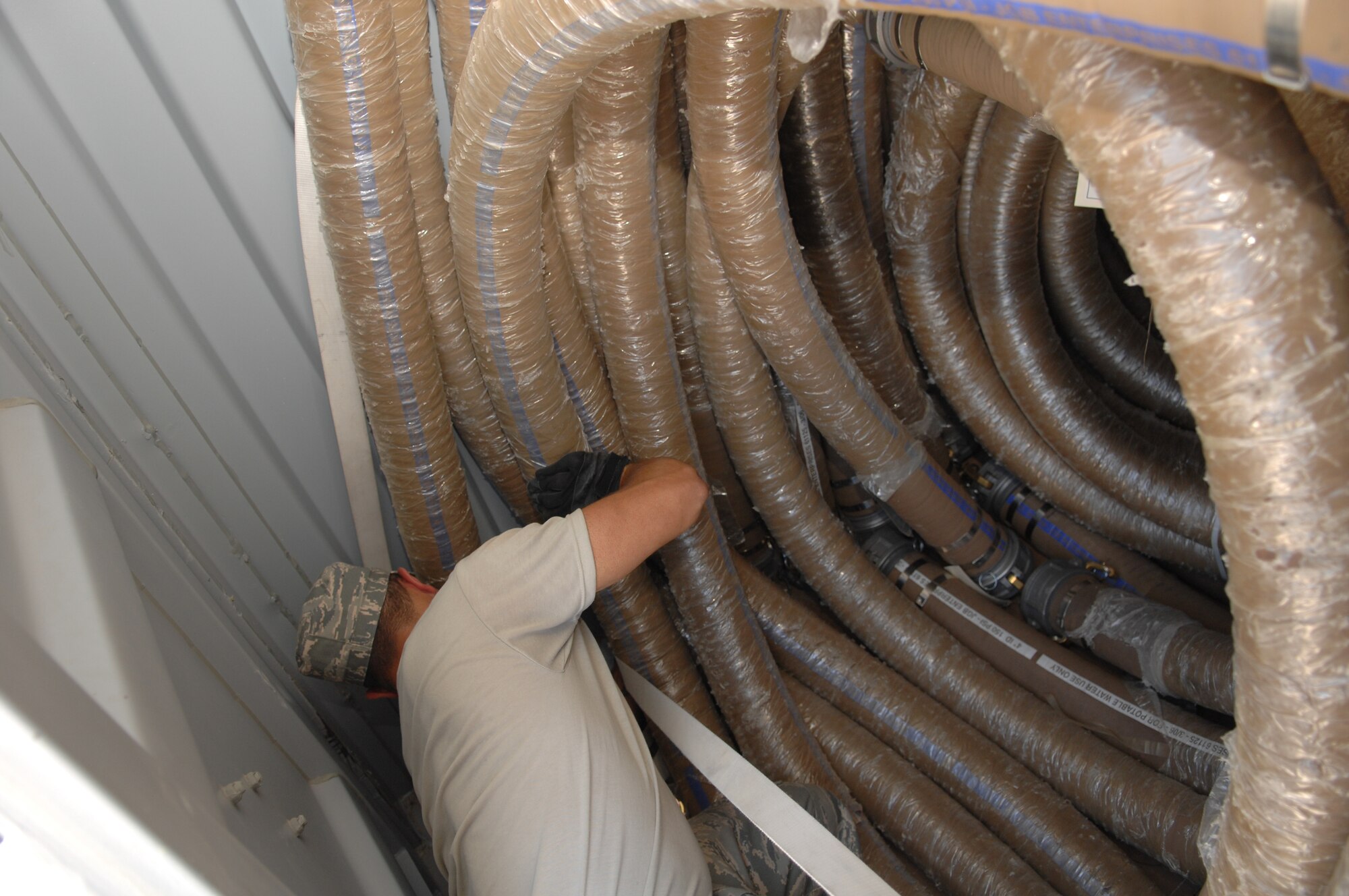 Airman 1st Class Beajan Setayesh, 49th Materiel Maintenance Squadron, reconfigures hoses from a 600 Water Production package at Basic Expeditionary Airfield Resources (BEAR) Base at Holloman Air Force Base, N.M., August 1. The hose is used to transport purified water and is being configured to support the new BEAR Order of Battle (BOB) program that is in the works at BEAR base. (U.S. Air Force photo/Airman Sondra M. Wieseler)