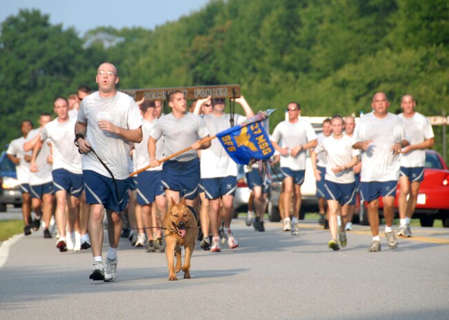 Brandon Serena leads the 437th Security Forces Squadron with his K-9, Rony, during the commander's 5,000 meter fitness challenge Aug. 1. This month's fitness challenge was designated by the commander to motivate Airmen for the operational readiness inspection that started Aug. 3. Serena is a K-9 handler with the 437 SFS. (U.S. Air Force photo/Airman 1st Class Cynthia Spalding) 