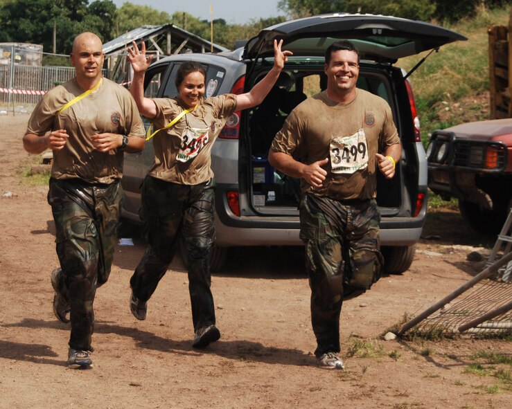 An exuberant Navy Lieutenant Katie Hall celebrates completing the Tough Guy Nettle Warrior XI challenge with her teamates Navy Lieutenant Commander Wayne Hill and Chief Petty Officer Nicholas Williams.  The three were members of the JAC-HAMMERS team fielded by the JIOCEUR Analytic Center, RAF Molesworth England in the July 27th event in Perton England.  All can now officially call themselves "Tough Guys.!" (U.S. Air Force Photo by Staff Sergeant Chad E. Chisholm)