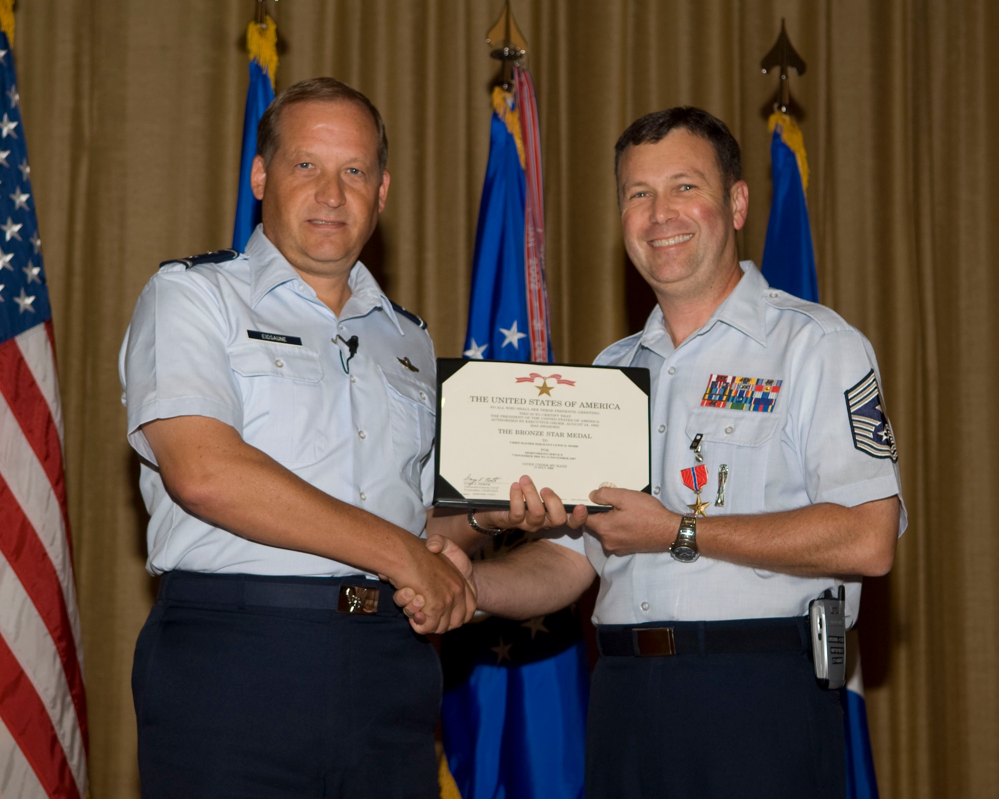 Gen. David Eidsaune presents Chief Master Sgt. Lewis Mohr the Bronze Star Medal at the commander's call July 31, for meriotorious achievement while Command Chief Master Sergeant, 376th Air Expeditionary Wing, Manas Air Base, Kyrgyz Republic.