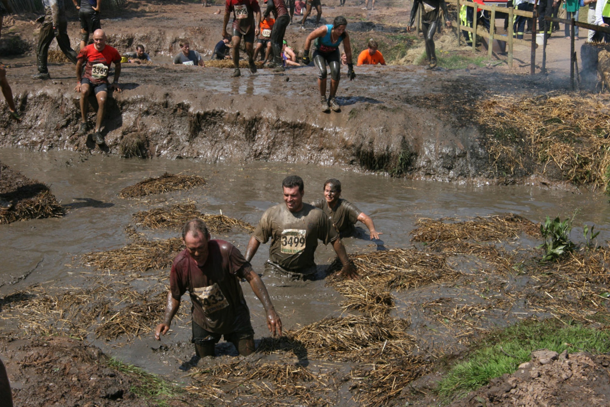Navy Chief Petty Officer Nicholas Williams #3400 and Lieutenant Katie Hall negotiate one of the many mud obstacles during the Tough Guy Nettle Warrior XI challenge held in Perton, England on July 27th.  Chief Williams and Lt. Hall are members of the nine-member JAC-HAMMERS team sponsored by the the JIOCEUR Analytic Center, RAF Molesworth, United Kingdom.  (U.S. Navy Photo by Chief Petty Officer Keith Van Hoosen)