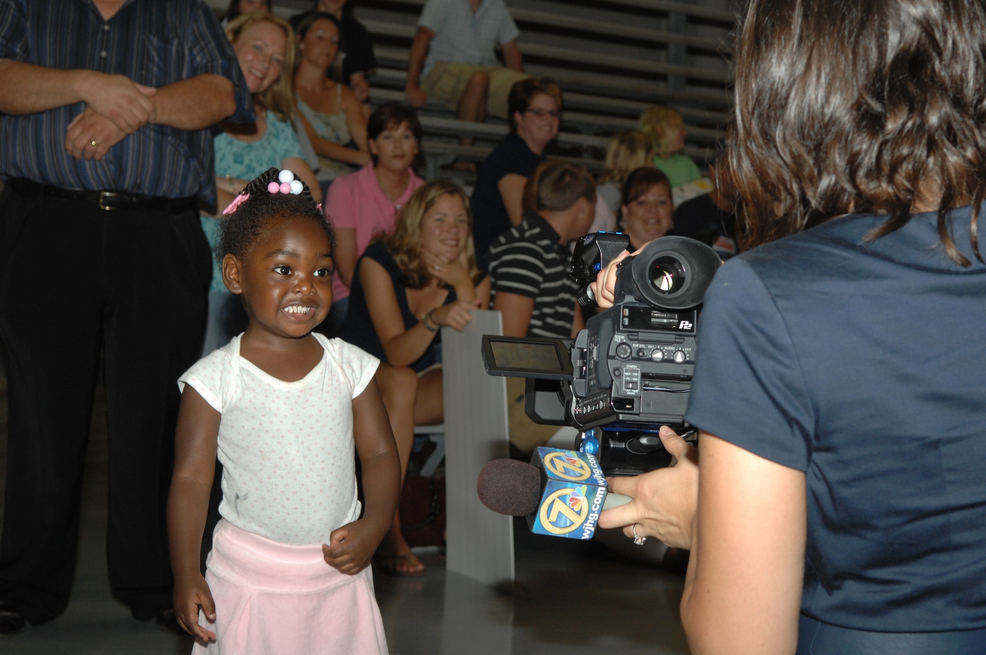 Ossiana Blakenship puts on her best smile for a television crew during the Operation Homecoming celebration that started at 1:30 a.m. Aug. 5. Ossiana was waiting to greet her grandfather, Staff Sgt. Van Lewis, 1st Special Operations Helicopter Maintenance Squadron. Nearly 200 Airmen were welcomed home from their deployments during the ceremony. (U.S. Air Force photo/Senior Airman Stephanie Jacobs)