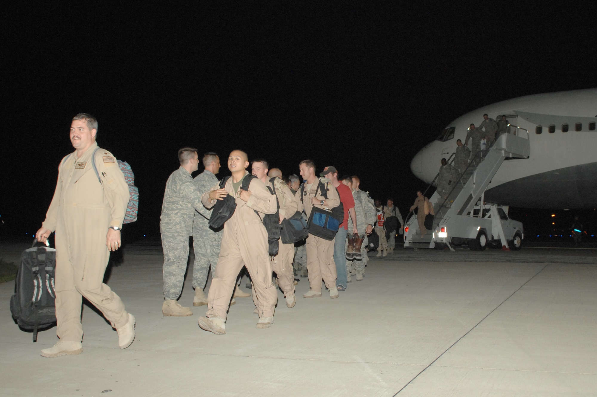 Airmen make their way from the airplane to the arms of their loved ones during the Operation Homecoming celebration that started at 1:30 a.m. Aug. 5. Nearly 200 Airmen were welcomed home from their deployments during the ceremony. (U.S. Air Force photo/Senior Airman Stephanie Jacobs)